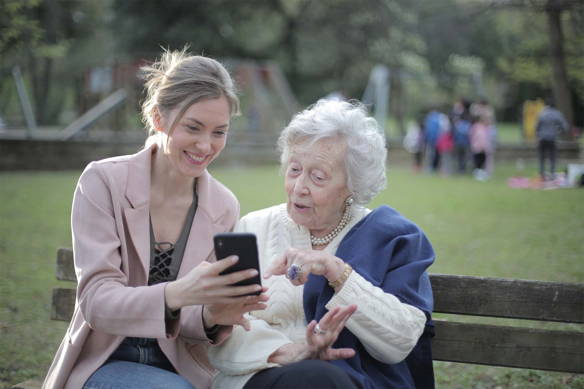 resident sat on a park bench with their carer