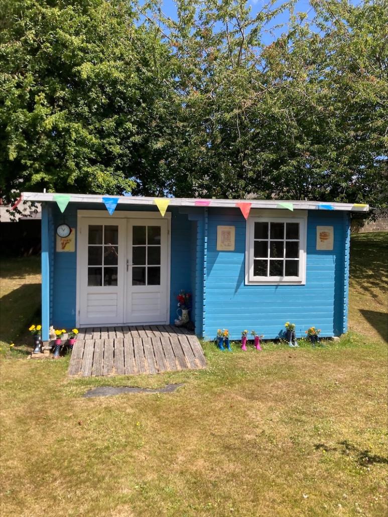 our summer house with colourful bunting and blue walls
