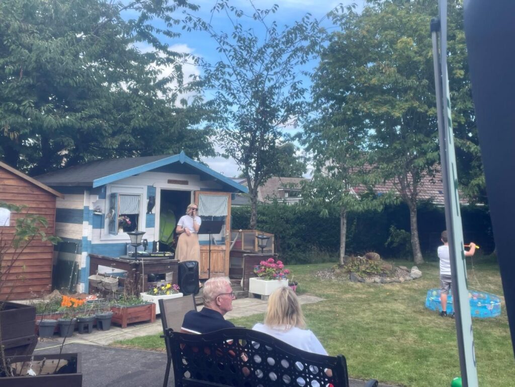 a entertainer with sunglasses singing in the garden